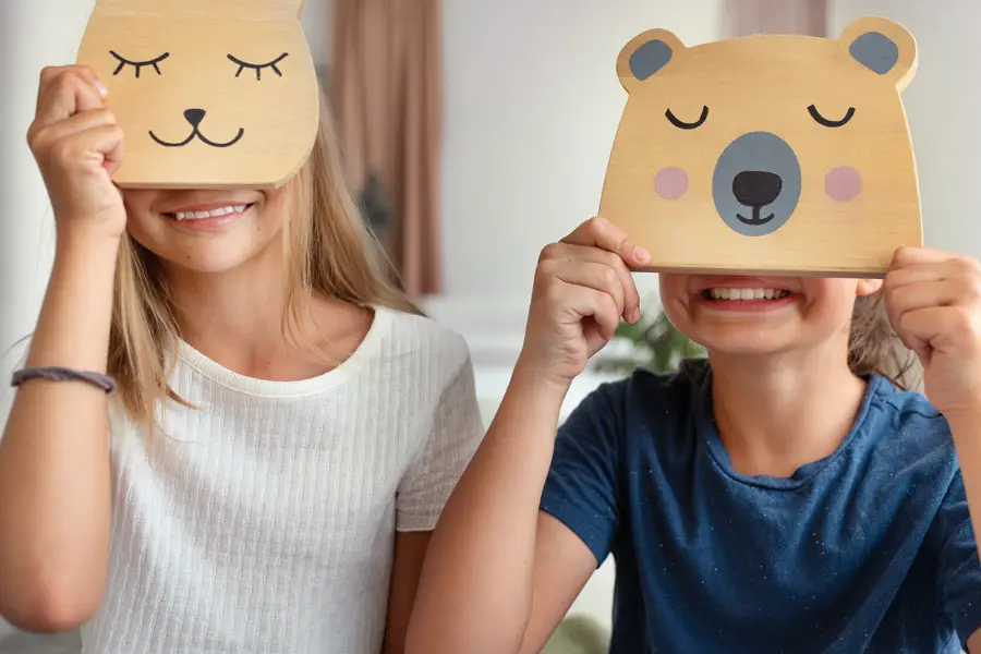 Children holding bear masks – playful expression of emotion through visual symbols